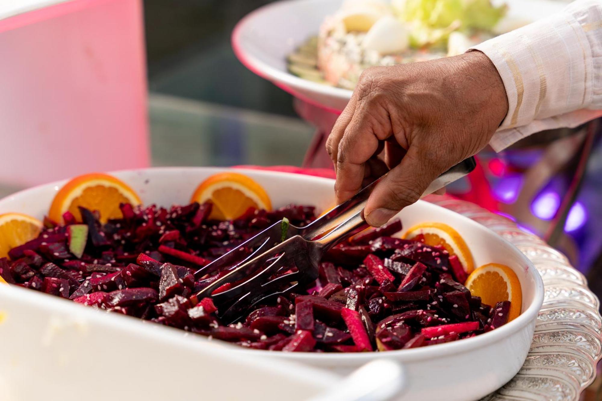 シェラトン ダンマン ホテル ＆ コンベンションセンター ダンマーム エクステリア 写真 A hand using a buffet server to serve food