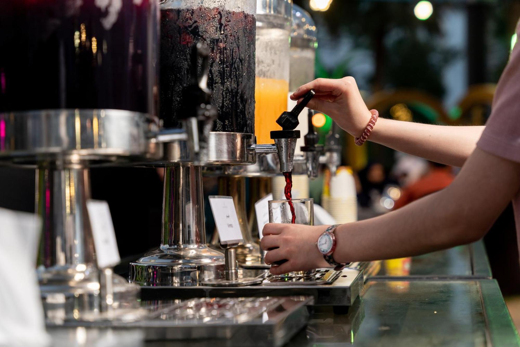 シェラトン ダンマン ホテル ＆ コンベンションセンター ダンマーム エクステリア 写真 A bartender using a tap to serve a drink